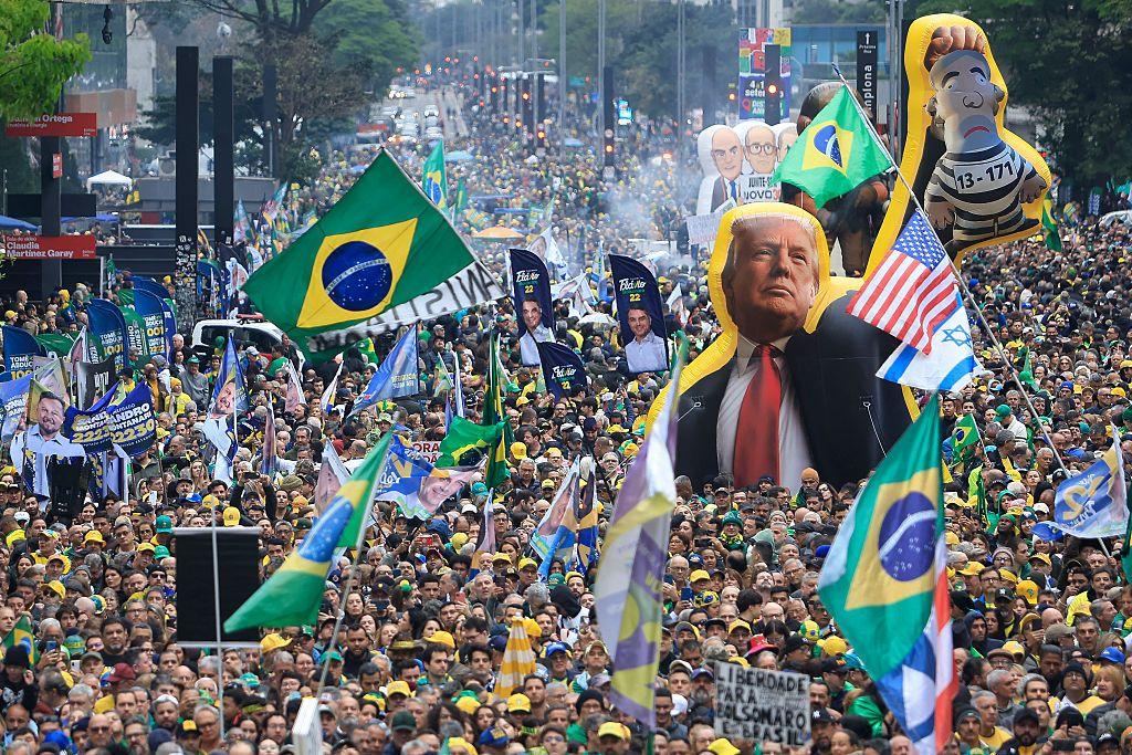 una imagen de Donald Trump junto a las banderas de Estados Undios, Israel y Brasil en un acto de partidarios del candidato Flávio Bolsonaro para las elecciones de Brasil en 2026