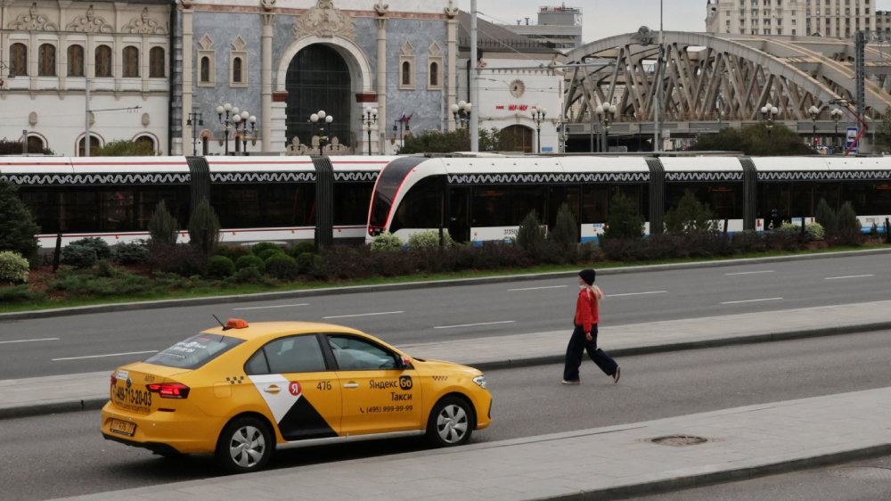 Varias personas pasan junto a un coche de Yandex Taxi frente a la estación de tren de Kazansky en Moscú, Rusia.